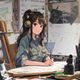 动漫角色设计师赵子涵的工作照，坐于绘图板前，创作状态中